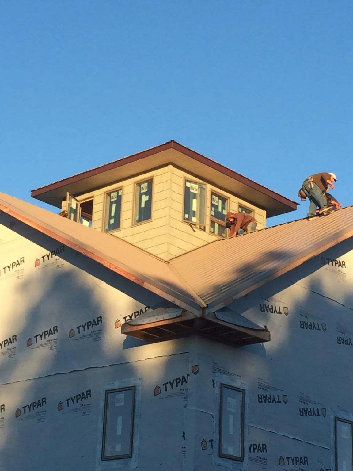 Roofers working around a rooftop cupola on a new metal roof at sunset — Roof Waterproofing in Shannon by Roofing Brothers